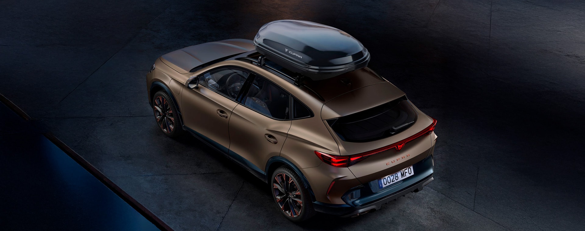 New century bronze CUPRA Formentor 2024 rear and towing bike rack car accessory, city skyline in the background.