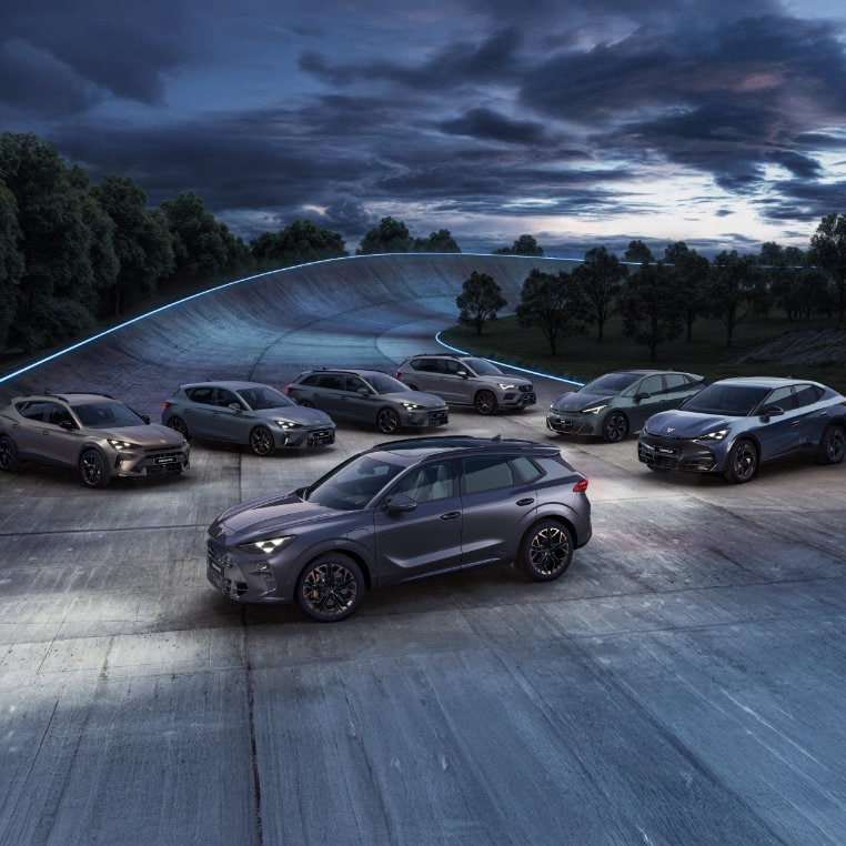 cupra car models’ welcome light with projected logo on pavement at night and cupra born electric vehicle in aurora blue close up