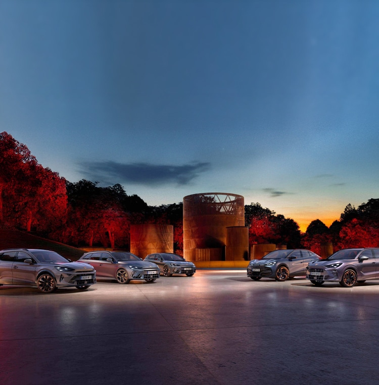 Electric vehicle at charging station, in car park, plugged in by car owner.