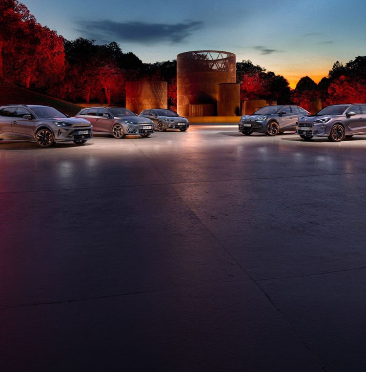 Electric vehicle at charging station, in car park, plugged in by car owner.