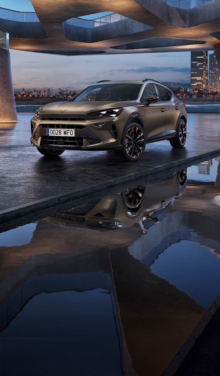 A CUPRA Terramar SUV shown from a high angle, appearing to be in motion with a red light streak extending from its side to a person lying horizontally in the air next to it.