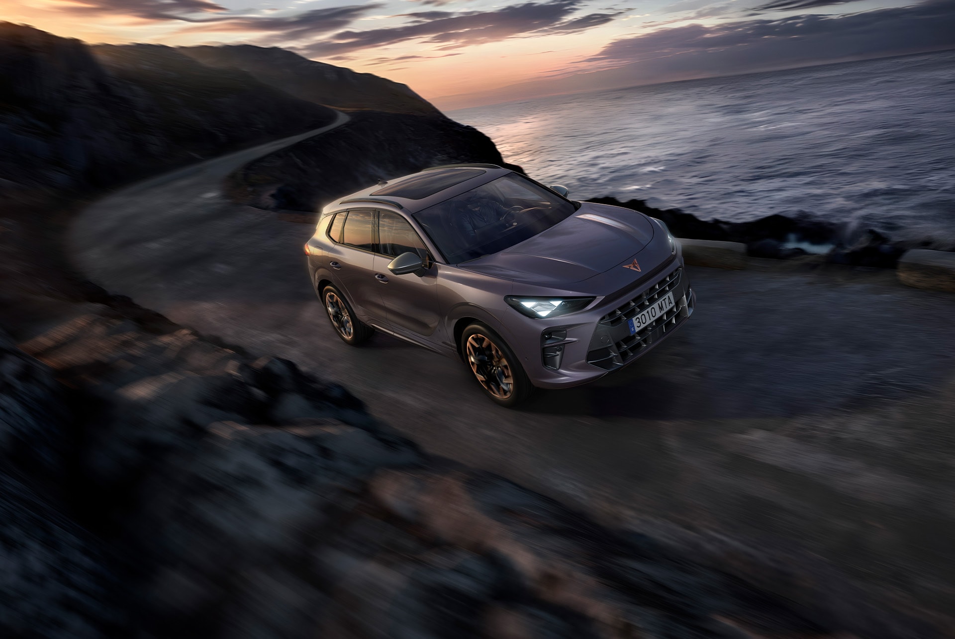 cupra terramar in versione esclusiva america's cup lungo una strada costiera, in grigio enceladus opaco e con cerchi in lega america's cup da 20 pollici.