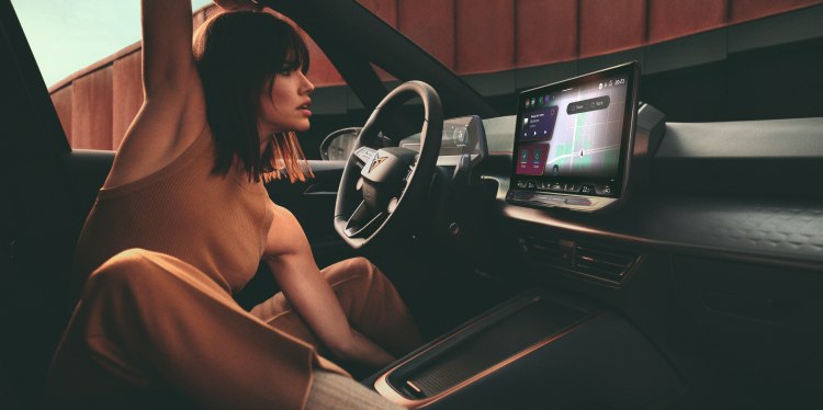 Una donna seduta comodamente all’interno di un’auto Cupra, mentre interagisce con il sistema di infotainment, a sottolineare il design moderno e il controllo offerto dal cupra way. 
